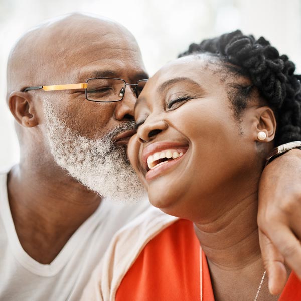 man kissing woman on cheek